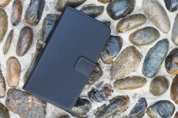 Smartphone leather case cover on gravel texture floor — Stock Photo, Image