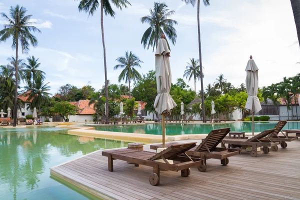 Wooden chairs on pool deck — Stock Photo, Image