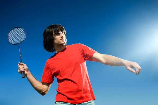 Hombre con raqueta sobre fondo azul Imagen de archivo