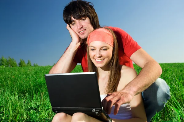 Girl with notebook and with boy on grass — Stock Photo, Image