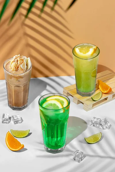 美丽的静物画 三杯透明的夏季饮料 绿色柠檬水 带有石灰 薄荷糖 柠檬和柑橘 热带背景 有棕榈树的影子 — 图库照片