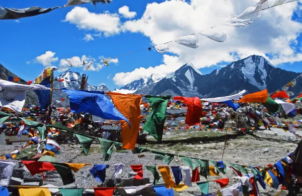 Bandeiras de oração tibetanas sopradas pelo vento com altos himalaias no fundo — Fotografia de Stock