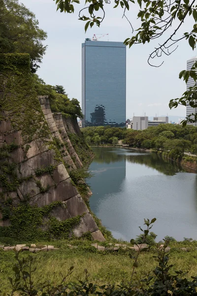 El foso del Castillo de Osaka con edificios modernos en la distancia — Foto de Stock