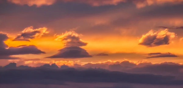 Orange sky at sunset with interestingly shaped clouds — Stock Photo, Image