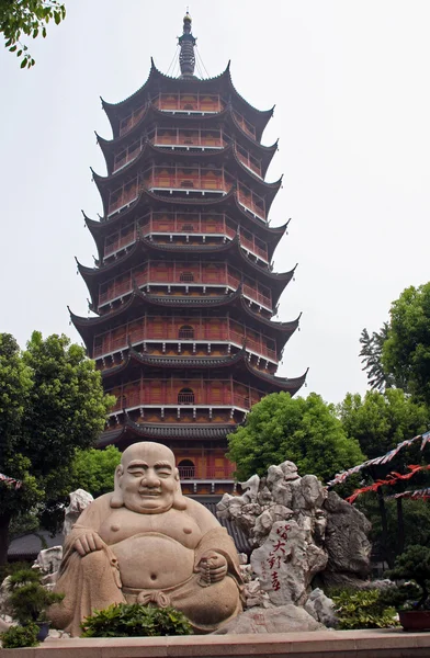 Statua buddha sorridente di fronte a una pagodda Ruigang distorta, S — Foto Stock