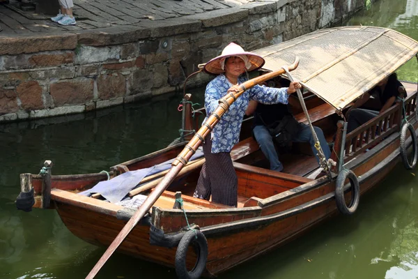 A boatwoman transports tuorists in her traditional wooden boat i