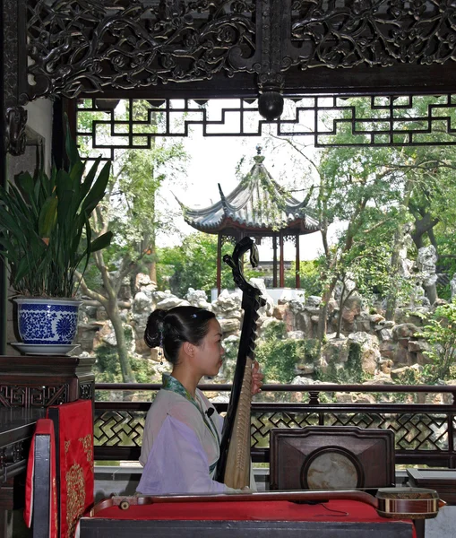 Jovem joga pipa em um show gratuito para turistas em um jardim em Suzhou — Fotografia de Stock