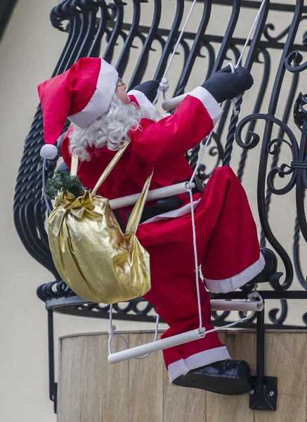 Big figurine of Santa Claus attached to a house's balcony so as