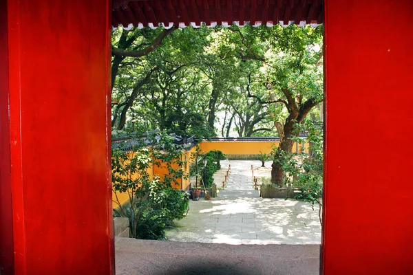 Porta vermelha revelando um belo pátio do templo em Putuo Shan, C — Fotografia de Stock