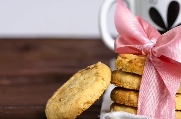 Festliche Schokoladenkekse mit Schleife umwickelt auf Holztisch, Makro. Schokoladenkekse lizenzfreie Stockbilder