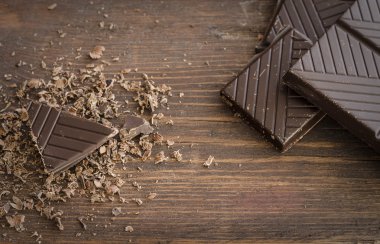 Bitter çikolata, toz kakao, Fransız macaron ve tarçın ahşap tablo