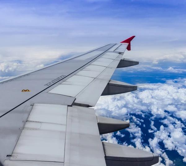 Wing of an airplane flying above the clouds. — Stock Photo, Image