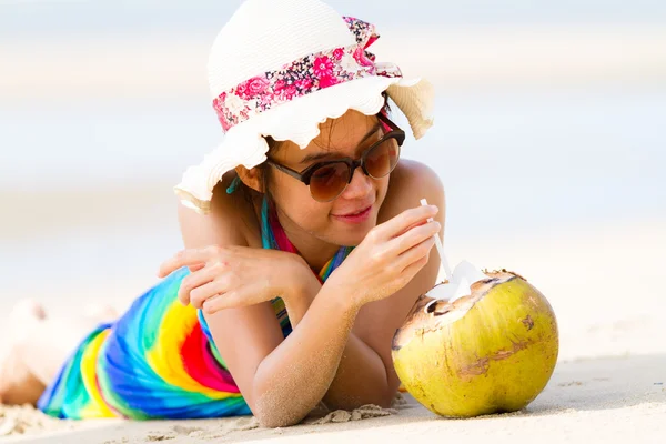 Jonge vrouw met kokos cocktail op het strand — Stockfoto