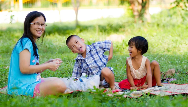 Glad mamma med sin dotter och son i parken — Stockfoto