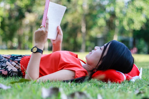 Hermosa joven estudiante leyendo libro sobre hierba —  Fotos de Stock