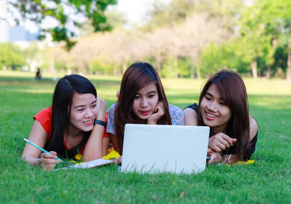 Skupina mladých studentů s počítačem studuje na jaře venku — Stock fotografie