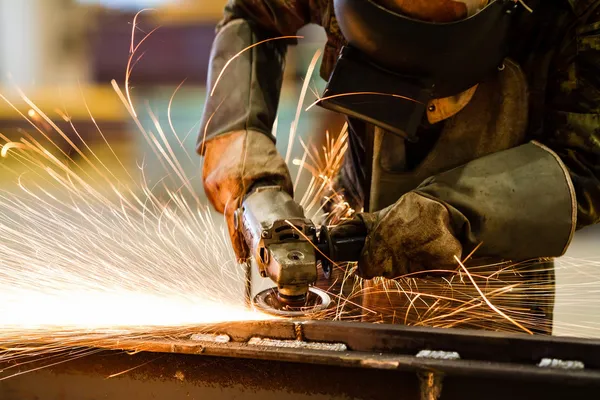 Elektrické broušení kol na ocelové konstrukci v továrně — Stock fotografie