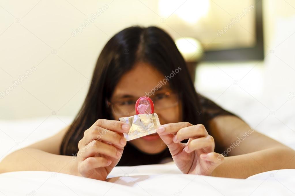 Asia woman opening a condom