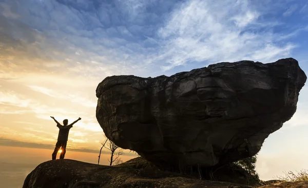 Uomo in cima alla montagna con grande roccia — Foto Stock