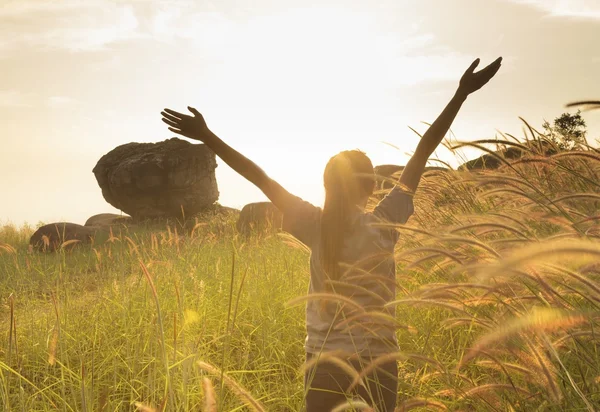 Chica joven extendiendo las manos con alegría e inspiración frente al sol —  Fotos de Stock