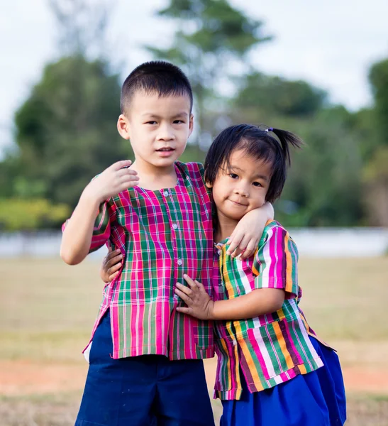 Un niño sonriente y una niña en el parque —  Fotos de Stock