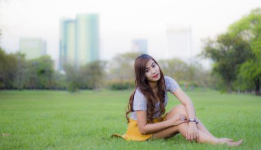 mutlu parkta oturan gülümseyen kadın