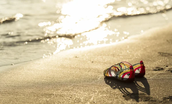 Обувь на пляже на закате — стоковое фото