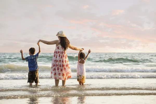 Boldog család áll a parton hajnalban — Stock Fotó