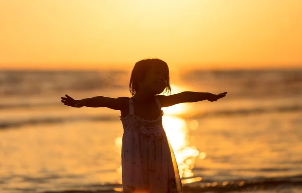 Glad tjej står på stranden på dawn tiden — Stockfoto