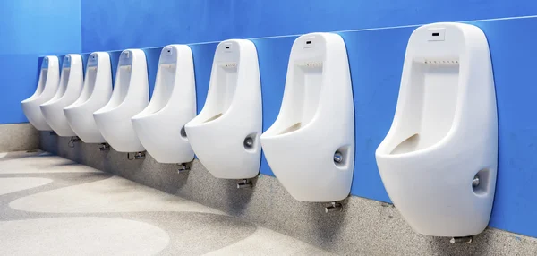 Lijn van wit porselein urinoirs in de openbare toiletten — Stockfoto