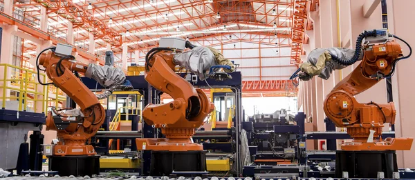 Roboty spawalnicze na linii produkcyjnej. Obraz Stockowy