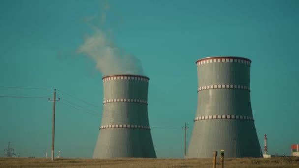 Ostrovets, region Grodno, Bělorusko - 21. července 2021: Jaderná elektrárna proti modré obloze. Koncepce jaderné energie. — Stock video