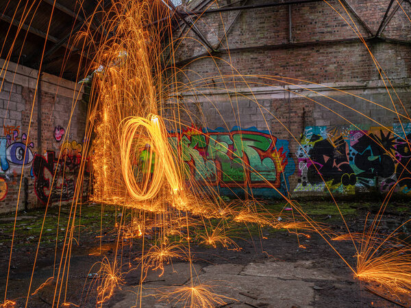 Дожди горячих светящихся искр из крутящейся стальной шерсти в старом здании