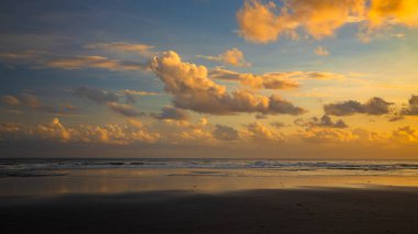 Gün batımı zamanı. Deniz manzaralı arka plan. Bulutlu gökyüzü. Manzaralı. Gün batımı altın saati. Suda güneş ışığı yansıması. Muhteşem bir manzara. Güzel doğa. Uzayı kopyala Kelanting Plajı, Bali, Endonezya