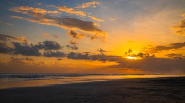 Gün batımı zamanı. Deniz manzaralı arka plan. Bulutlu gökyüzü. Manzaralı. Gün batımı altın saati. Suda güneş ışığı yansıması. Muhteşem bir manzara. Güzel doğa. Uzayı kopyala Kelanting Plajı, Bali, Endonezya