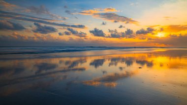 Gün batımı zamanı. Deniz manzaralı arka plan. Bulutlu gökyüzü. Manzaralı. Gün batımı altın saati. Suda güneş ışığı yansıması. Muhteşem bir manzara. Muhteşem manzara fotokopi uzayı. Kelanting Plajı, Bali, Endonezya