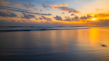 Gün batımı zamanı. Deniz manzaralı arka plan. Bulutlu gökyüzü. Manzaralı. Gün batımı altın saati. Suda güneş ışığı yansıması. Muhteşem bir manzara. Muhteşem manzara fotokopi uzayı. Kelanting Plajı, Bali, Endonezya