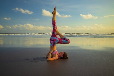Plaj yogası Slim Kafkasyalı kadın Sarvangasana çalışıyor. Omuz ayağa kalk. Bir bacağı bükülmüş. Ters dönmüş Asana. Yoga inzivası. Güçlü vücut. Sağlıklı bir yaşam tarzı. Yatay yerleşim planı. Uzayı kopyala Bali Endonezya