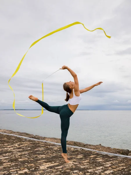 Mladá Profesionální Gymnastka Tančící Žlutou Stuhou Venkovní Tělocvik Zatažené Pozadí — Stock fotografie