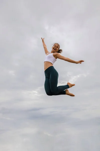 Slim Kafkasyalı Genç Bir Kadın Bulutlu Gökyüzünden Atlıyor Beyaz Kadın — Stok fotoğraf
