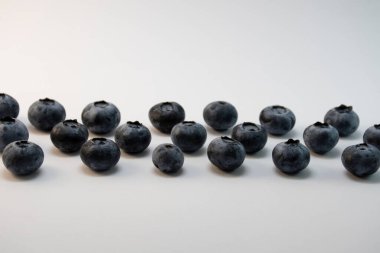 Beyaz arka planda dizilmiş yaban mersini.