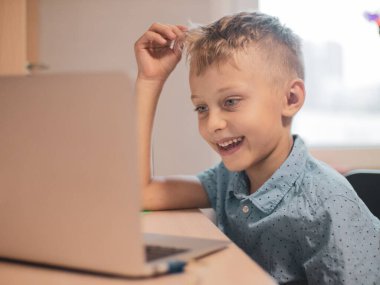 Çevrimiçi öğrenim sınıfı çalışması, Zoom öğretmeni, Mutlu çocuk evde dizüstü bilgisayarla İngilizce öğreniyor. Yeni normal. Covid-19 Coronavirus. Sosyal mesafe. Evde kal.