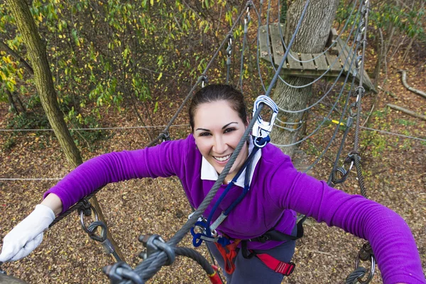 Donna che si arrampica nel parco avventura — Foto Stock