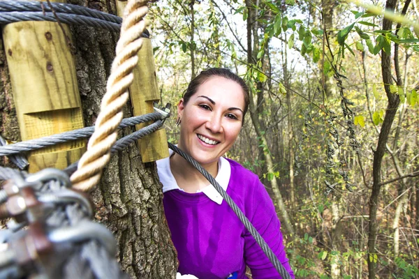 Donna che si arrampica nel parco avventura — Foto Stock