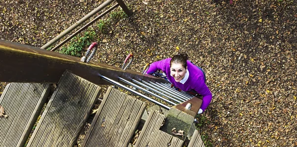 Donna che si arrampica nel parco avventura — Foto Stock