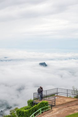 Couple looking at the view, The most beautiful place to see clouds and mist at the view in Thailand, Phu Thap Boek, Phetchabun, in Thailand.