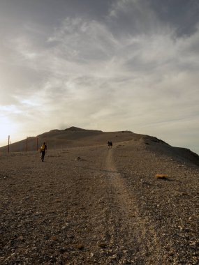 Arkadaşlar gün batımında dağda yürüyorlar