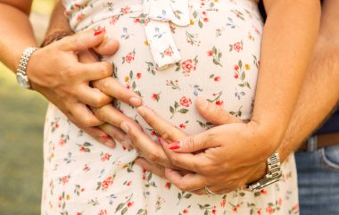 Karnına sarılan çiftlerin elleri.