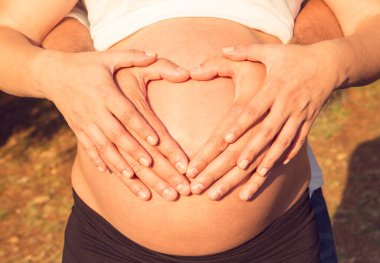 Çiftin elleri hamilelik karnında kalp yapıyor