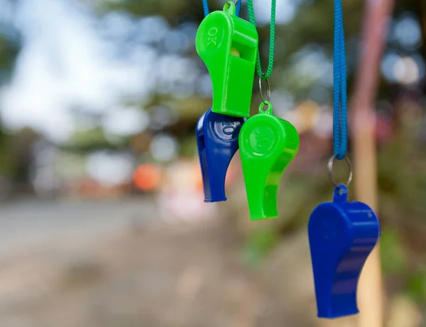 green and blue whistles on unfocused background